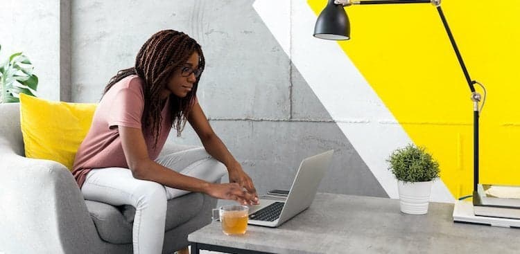 person sitting on a couch with a laptop